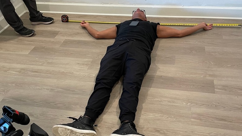 Marcus Lemonis measuring home's wall