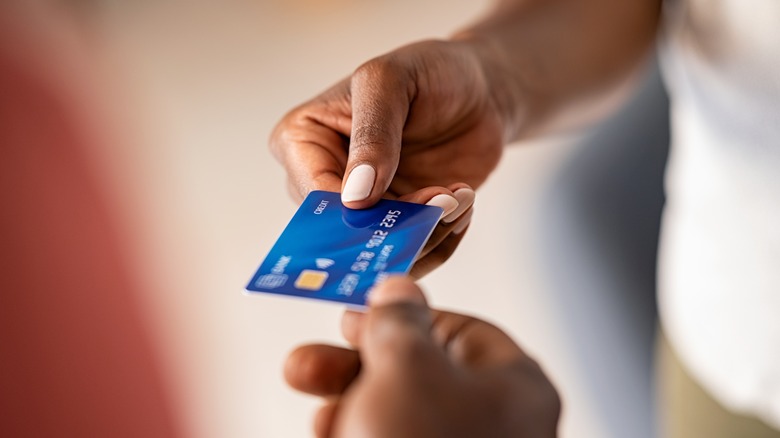 Person handing over card cashier