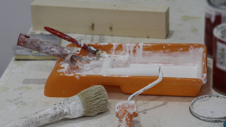 Well-used paint tray, rollers and brushes