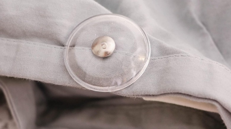 Pinion Pin in place on a gray duvet cover