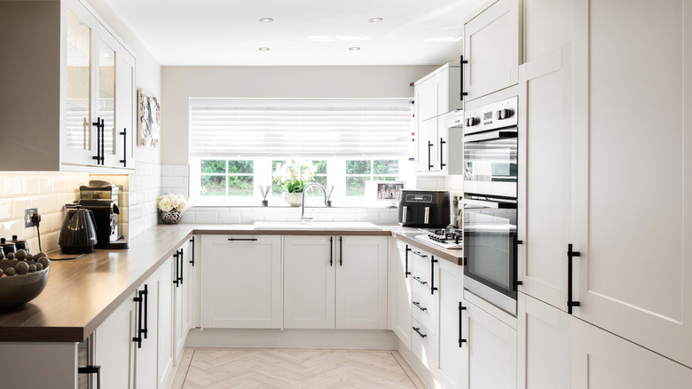 All white kitchen with dark brown countertops