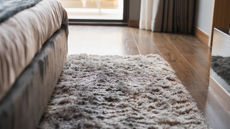 Gray faux fur rug under bed