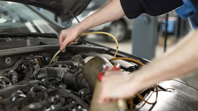 man draining brake fluid