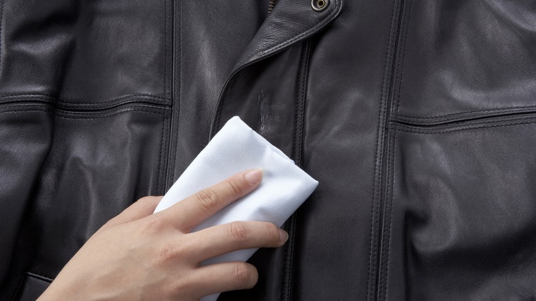 Person cleaning leather jacket