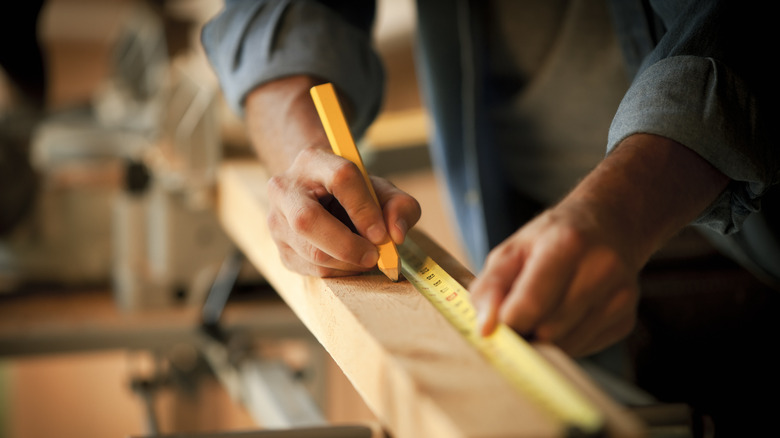 Person measuring wood 