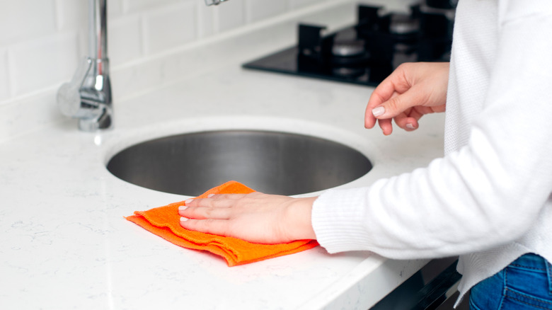 Woman wipes counter around sink