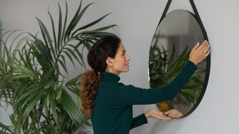 Person hanging wall mirror