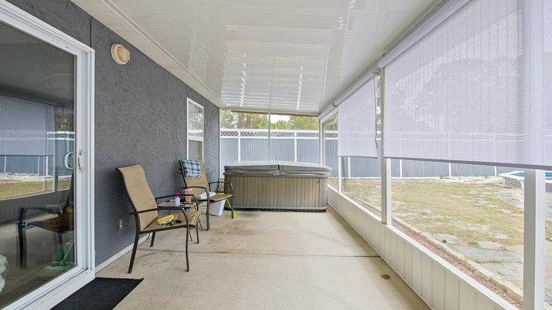 screened-in porch with hot tub