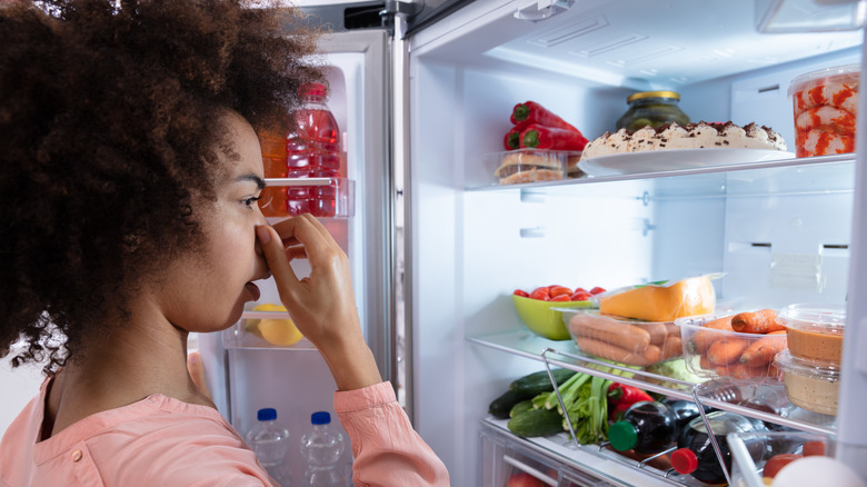 woman cleaning smelly fridge