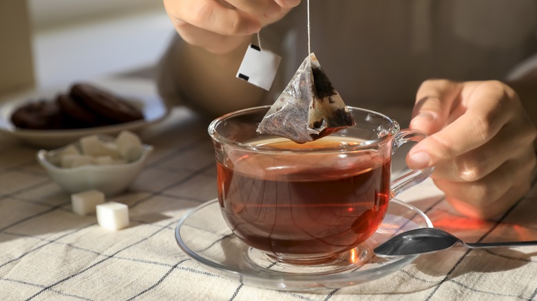 Draining a tea bag from a cup of tea