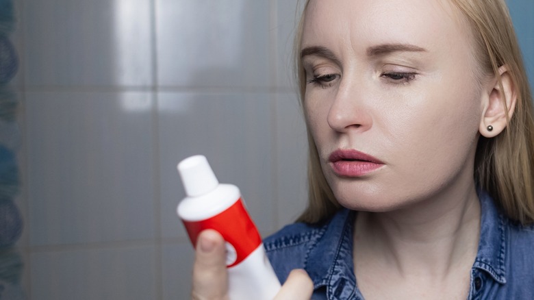 woman reading a toothpaste tube