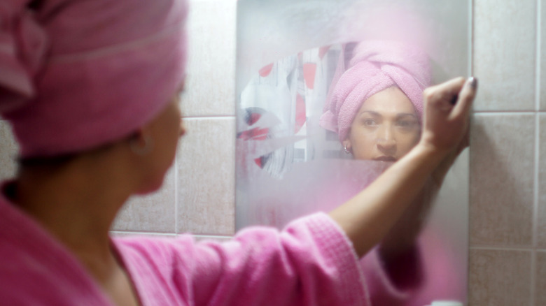 woman looking in steamy mirror