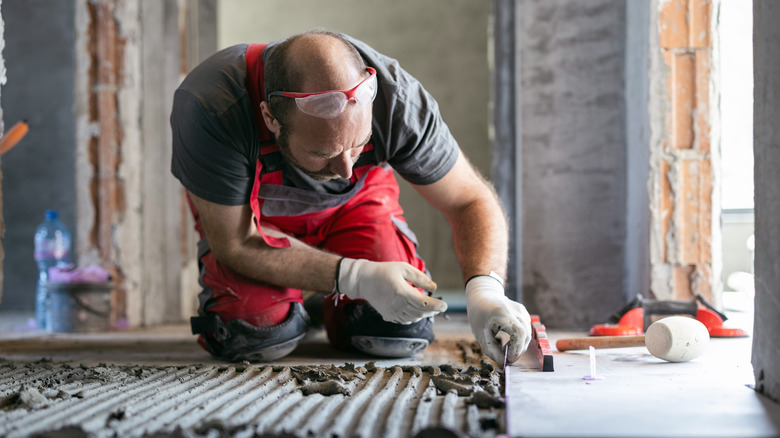 Man installing tile floor