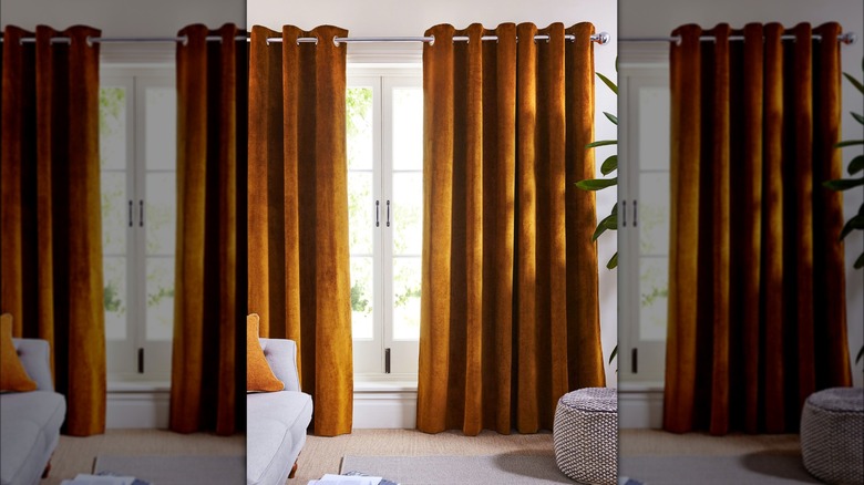 Brown floor length velvet curtains frame windows in living room