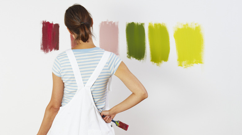 woman deciding on paint samples on wall