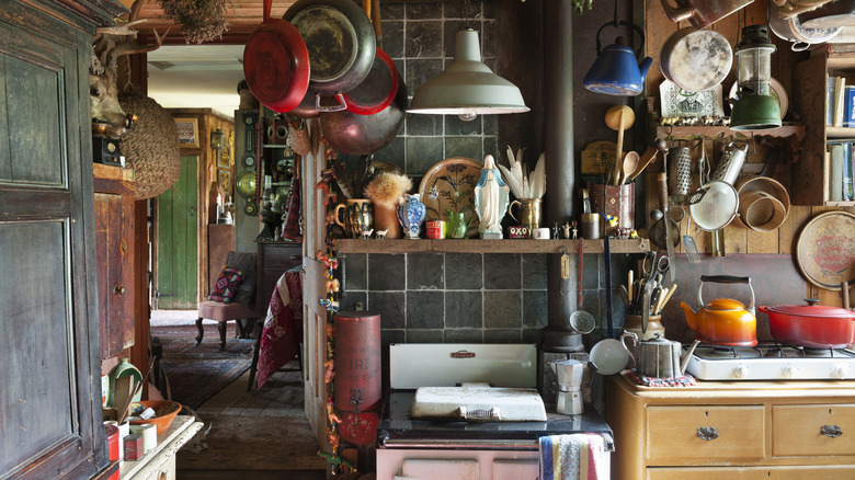 A small cottage kitchen is cluttered with cookware