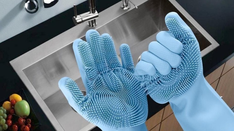 Hands wearing silicone scrubbing gloves