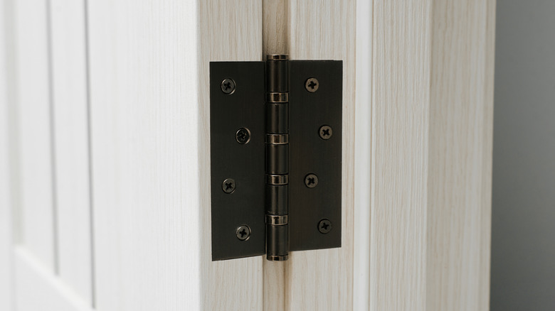 Black door hinge on white door