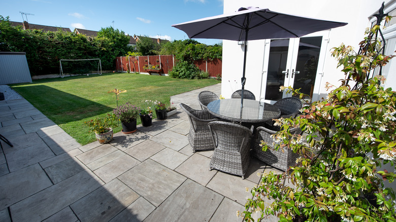 A finished patio with patio furniture and landscaped lawn