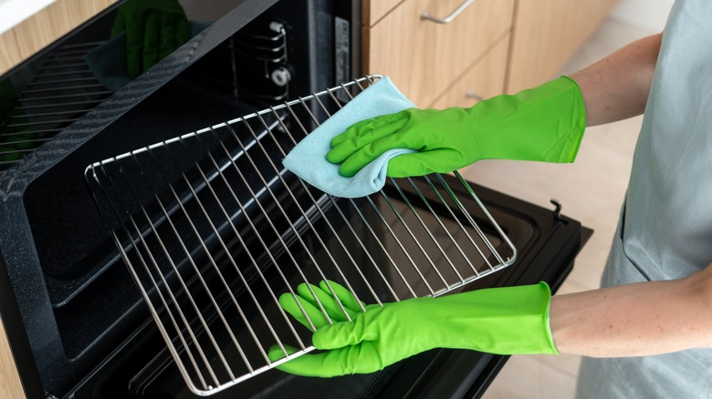 Person cleaning oven wire rack