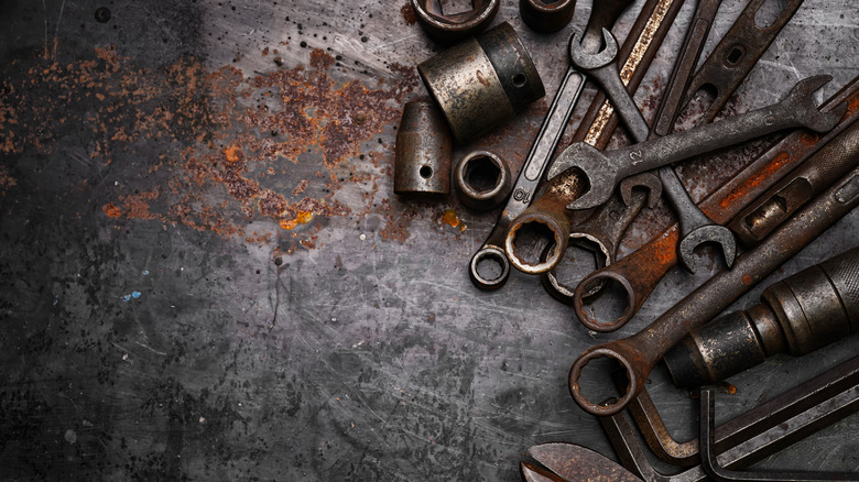 Rusty tools laying on rusted surface