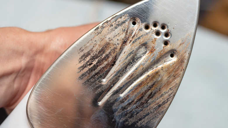 The underside of an iron with burn dirty surface