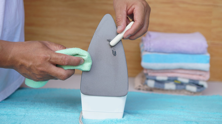 A person using a soft cloth and brush to clean a burnt iron