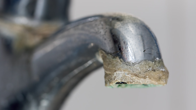 Faucet with thick limescale buildup on the spout