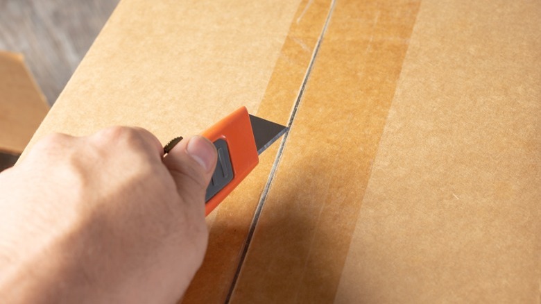 box cutter cutting packing tape