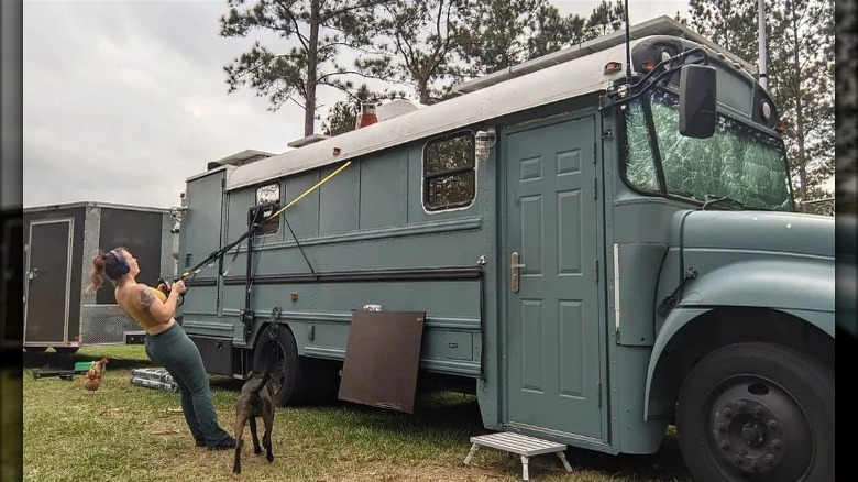 Woman exercising by converted schoolbus