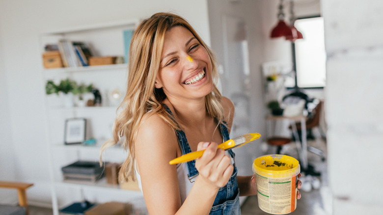 Woman holding bright yellow paint