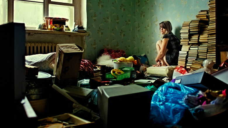 person sitting in cluttered room