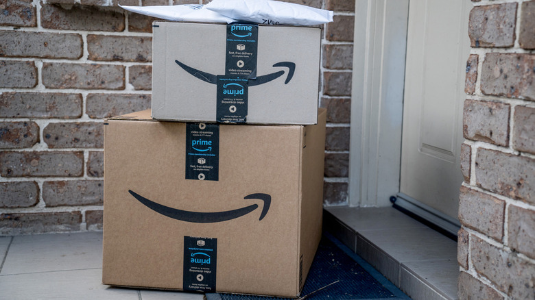 Amazon shipping boxes on mat in front of a residential door