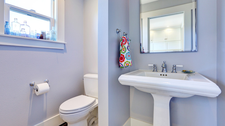 A small bathroom with pale lavender walls