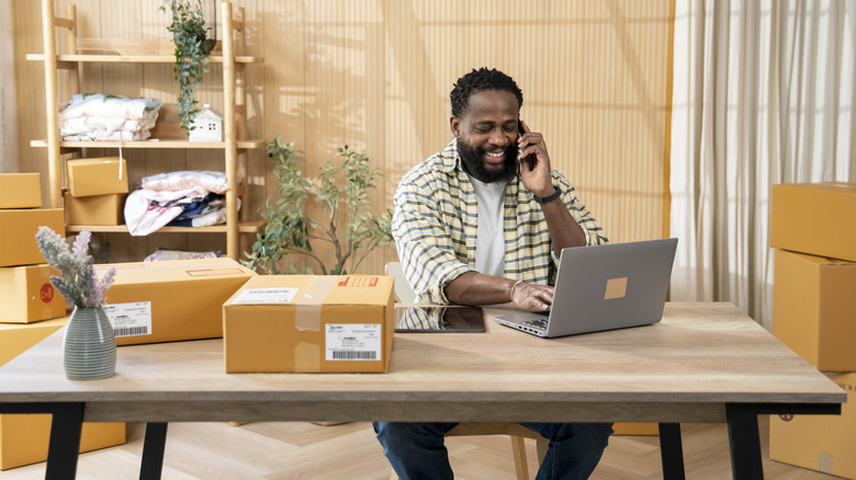 Man working from his home office on his kitchen table desk