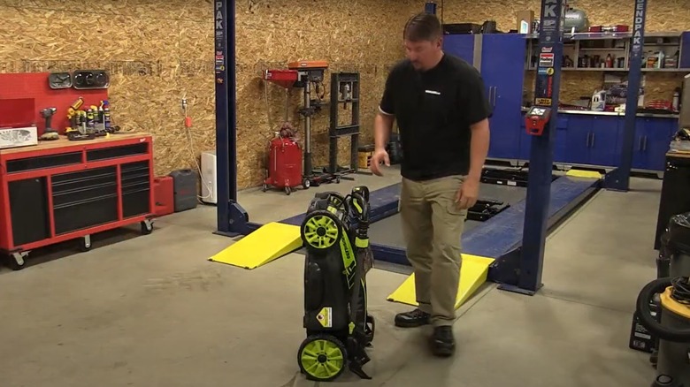 man storing mower in upright position