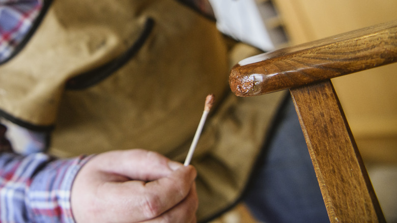 Man applying stain using q tip