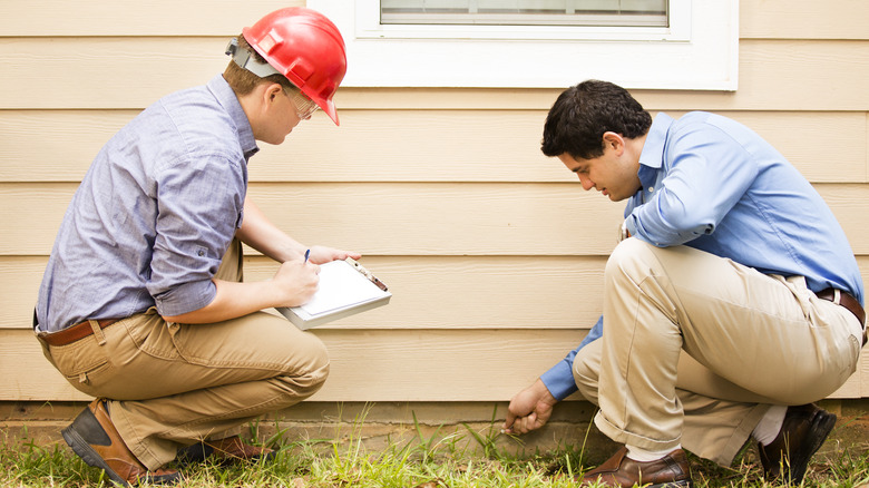 Construction workers inspecting home's foundation