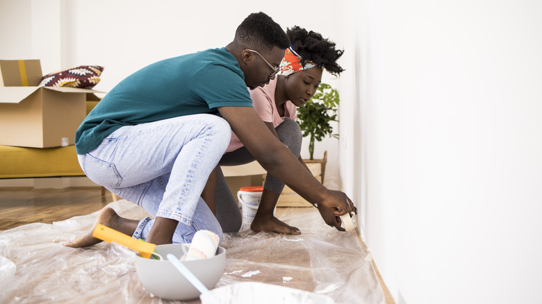 Couple painting a wall