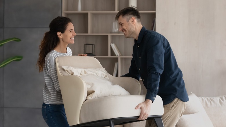 couple moving furniture smiling