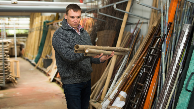 man buying long bamboo poles