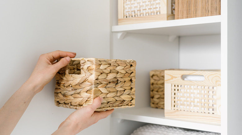 hands holding wicker basket closet