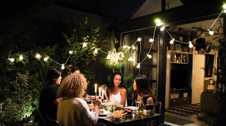 Women sitting under string lights