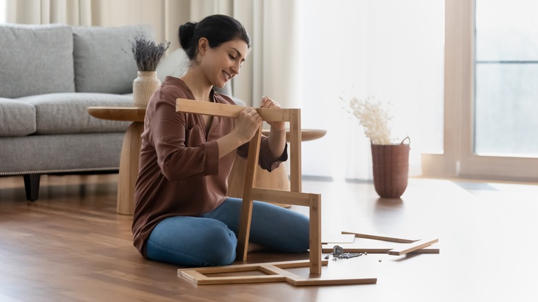 woman assembling storage cabinet