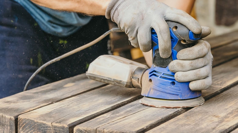 Person sanding wood table