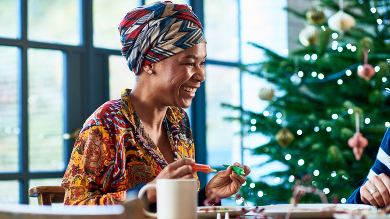 Woman crafting near Christmas tree