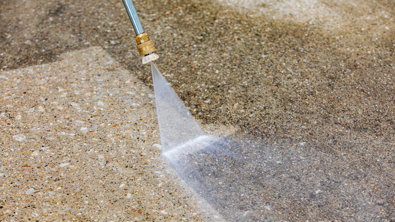 Spraying concrete surface with water