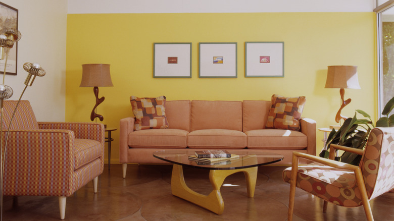 Living room with pink retro furniture and yellow wall