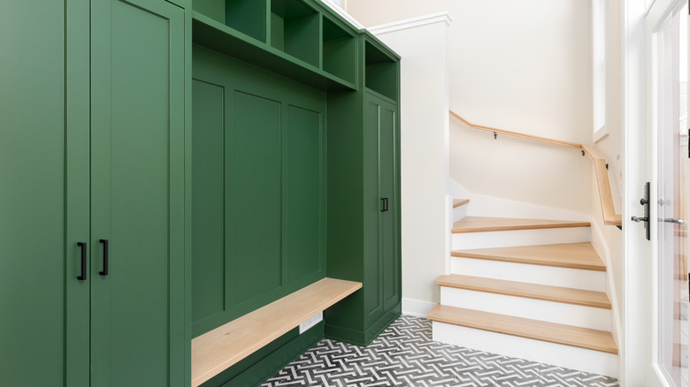 Mudroom with green cabinets and back stairwell