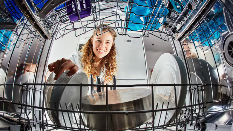 woman stacking dishes in dishwasher